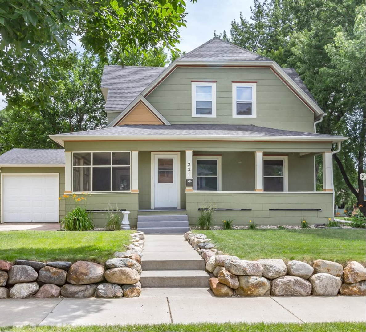 Green craftsman home with stone steps