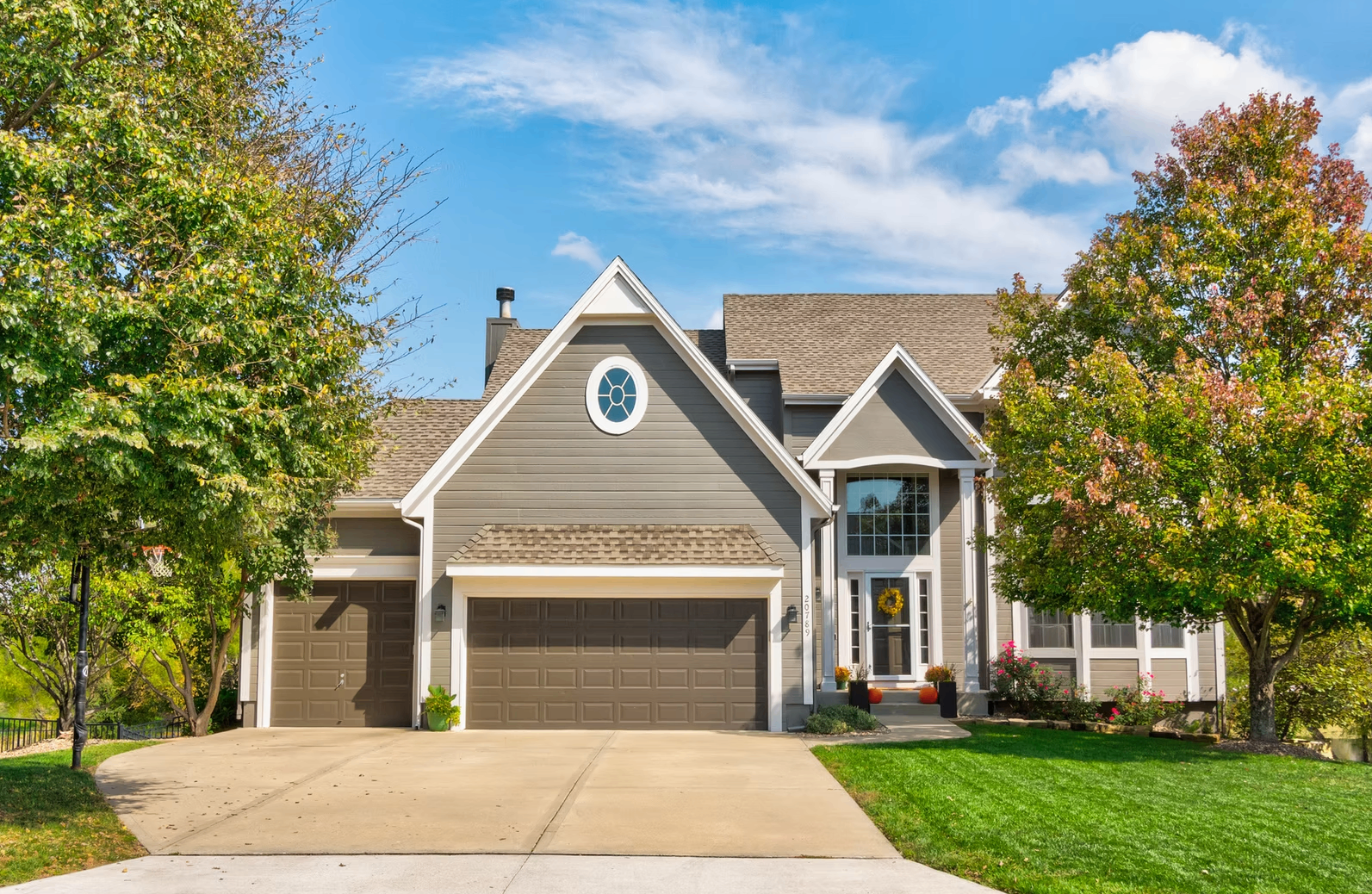 Two-story home with autumn trees